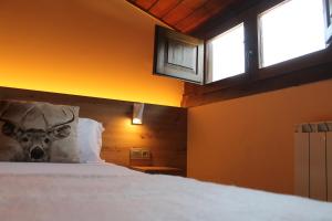 a bedroom with a bed with a cow on the pillow at Hotel Saurat in Espot