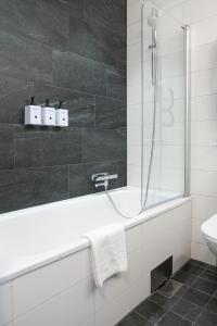 a bathroom with a bath tub and a sink at Hotel Birger Jarl in Stockholm