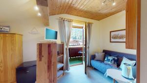 ein Wohnzimmer mit einem blauen Sofa und einem TV in der Unterkunft Chalet Tirol Waidring in Waidring