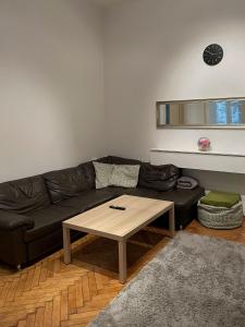 - un salon avec un canapé noir et une table basse dans l'établissement Apartment 1080, à Vienne