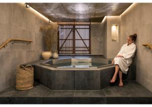 厄勒布魯的住宿－厄勒布魯克拉麗奧酒店，坐在浴室浴缸里的女人