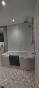 a bathroom with a bath tub in a room at A home away from home in Torquay