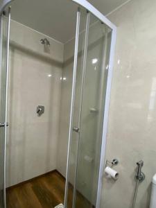 La salle de bains est pourvue d'une douche avec une porte en verre. dans l'établissement Apartamento en Barrio Sur DOS HABITACIONES, à Montevideo