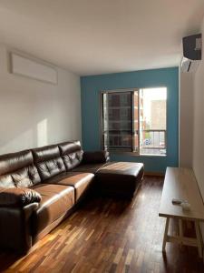 sala de estar con sofá de cuero y mesa en Apartamento en Barrio Sur DOS HABITACIONES en Montevideo