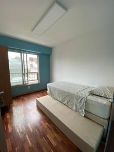 モンテビデオにあるApartamento en Barrio Sur DOS HABITACIONESのベッドルーム(ベッド1台、ベンチ付)