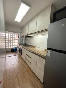 eine Küche mit weißen Schränken und einem Kühlschrank in der Unterkunft Apartamento en Barrio Sur DOS HABITACIONES in Montevideo