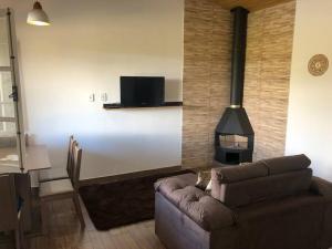 uma sala de estar com um sofá e um fogão em Aconchegante Chalé - Recanto dos Canários 