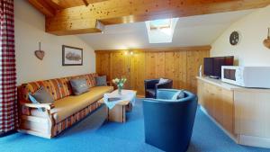 a living room with a couch and a tv at Chalet Tirol Waidring in Waidring