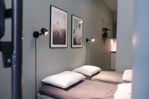 オスロにあるAnker Apartment – Grünerløkkaの白い枕が付いたベッド3台が備わる客室です。
