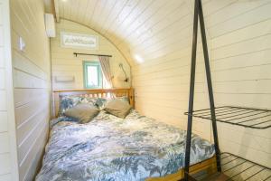 um quarto com uma cama num pequeno quarto em Pendragon Pod em Axminster