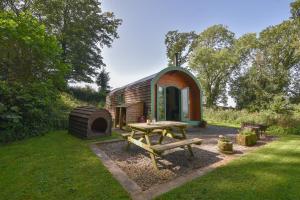 a tiny house with a picnic table in the yard at Pendragon Pod in Axminster