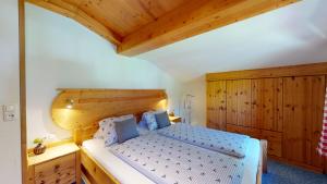 a bedroom with a bed and a wooden ceiling at Chalet Tirol Waidring in Waidring