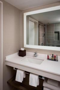 y baño con lavabo blanco y espejo. en Albuquerque Marriott Pyramid North, en Albuquerque