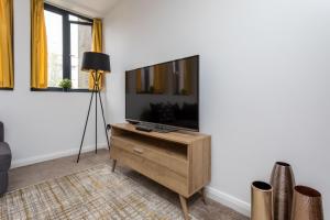una sala de estar con TV de pantalla plana en una cómoda en Flat 7- Spacious Studio Flat in The Heart of Crawley, en Crawley