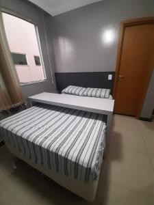 uma cama num quarto com uma janela em Apartamento Completo e Aconchegante em Lagoa Santa