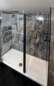 a shower with a glass door in a bathroom at Spinners Cottage - Central Kirkby Lonsdale Retreat in Kirkby Lonsdale