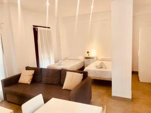 sala de estar con sofá y 2 camas en Apartamentos Pintor Losada en Córdoba