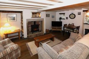 sala de estar con 2 sofás y chimenea en Spinners Cottage - Central Kirkby Lonsdale Retreat, en Kirkby Lonsdale