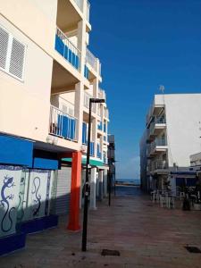 una fila de edificios altos junto al océano en Appartamento incantevole in centro Es Pujols, en Es Pujols