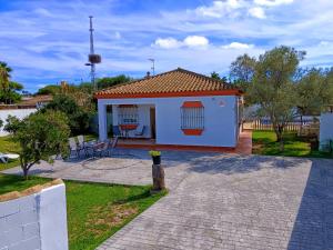 een klein wit huis met een patio bij Chalet Mari Carmen in Chiclana de la Frontera