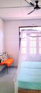 a bedroom with an orange bed and a window at Nilamba Beach Resort in Kovvankulam