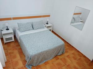 1 dormitorio con cama y espejo en la pared en Chalet Mari Carmen, en Chiclana de la Frontera
