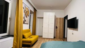 um quarto com uma cadeira amarela e uma cama em SalzinnesChezSoi em Namur