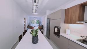 a kitchen with white counters and a vase with a plant at STAY Vital Elegance in Limassol