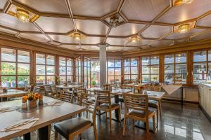 a restaurant with wooden tables and chairs and windows at Zur Blume Hotel & Restaurant Efringen-Kirchen bei Basel in Efringen-Kirchen