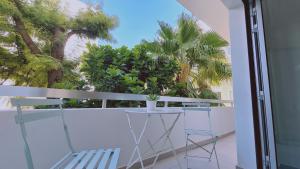 d'un balcon avec une table, des chaises et des palmiers. dans l'établissement STAY Vital Elegance, à Limassol