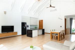 uma sala de estar com uma mesa e uma cozinha em SEA VILLA HỒ TRÀM em Ho Tram