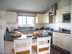 a kitchen with a table with a plate of food on it at Bay View Lodge, Brynowen in Borth