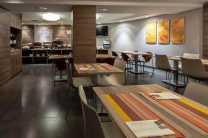 ポンフェラーダにあるHotel Aroi Ponferradaのテーブルと椅子のあるレストラン、キッチンが備わります。
