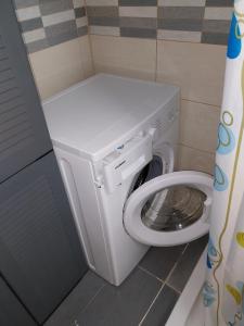 een witte wasmachine in een kleine badkamer bij Mikis Studio Type Aprt. in Larnaka