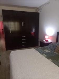 a bedroom with a bed and a dresser with a lamp at CASA RUBIA MORENO in La Banda