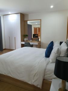 a bedroom with a large white bed with blue pillows at SEA VILLA HỒ TRÀM in Ho Tram
