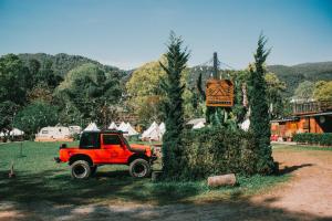 Ban Na YangInthanon Mountain Camp的停在树旁田野里的一辆红色卡车