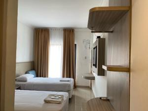Sukarami的住宿－Belvena Makati Hotel，酒店客房设有两张床和电视。