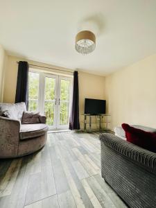 a living room with a couch and a television at Lovely 2 bedrooms apartment in Portsmouth