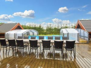 a deck with chairs and a table and a pool at 18 person holiday home in Ansager in Ansager