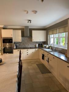 a kitchen with white cabinets and a counter top at Westwood Cottage in Aboyne