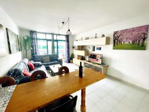a living room with a table and a couch at Casita Mara! 2’ Line to the sea, shops and bar’s in Puerto del Carmen