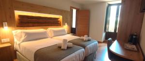 a bedroom with a large bed with two white pillows at Hotel Saurat in Espot