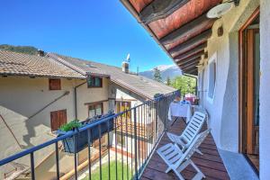 - un balcon avec deux chaises blanches et une table dans l'établissement San Marco Lodge Apt Mountain Retreat - Happy Rentals, à Oulx