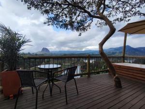 a patio with a table and chairs on a deck at Breeze Glamping -Guatape in El Peñol