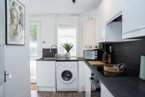 uma cozinha branca com uma máquina de lavar roupa em Montpellier Villa 