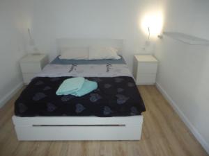a bed in a small room with two night stands at arad rooms & apartments חדרי אירוח ערד in Arad