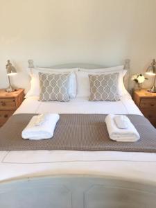 a bedroom with a bed with two towels on it at Chy Bownder Cottage in Lostwithiel
