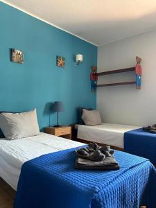 a room with two beds and a blue wall at Apartamento A11 - 800m da praia in Albufeira