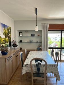 a dining room with a table and chairs and a kitchen at Apartamento A11 - 800m da praia in Albufeira